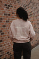 woman wearing pink greater things sweatshirt back